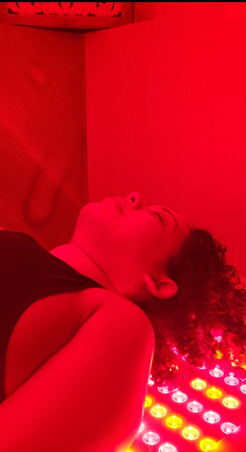 Client relaxing during a Red Light Therapy session at All Natural Wellness Center