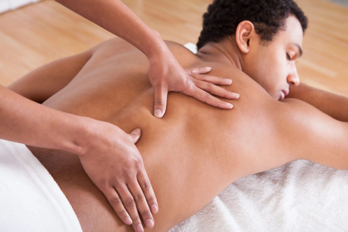 Massage therapist performing therapeutic massage for back pain at All Natural Wellness Center in Fort Lauderdale